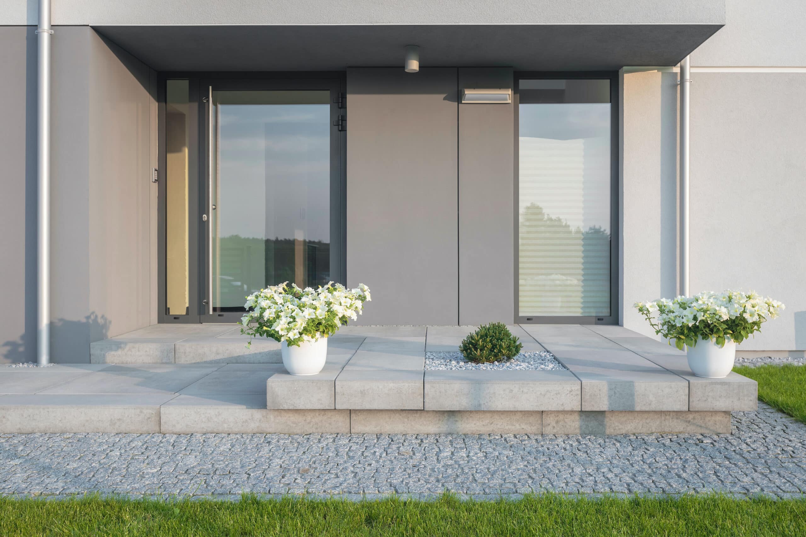 Reynaers residential doors showing a  CS77 front door with full glass on a porch