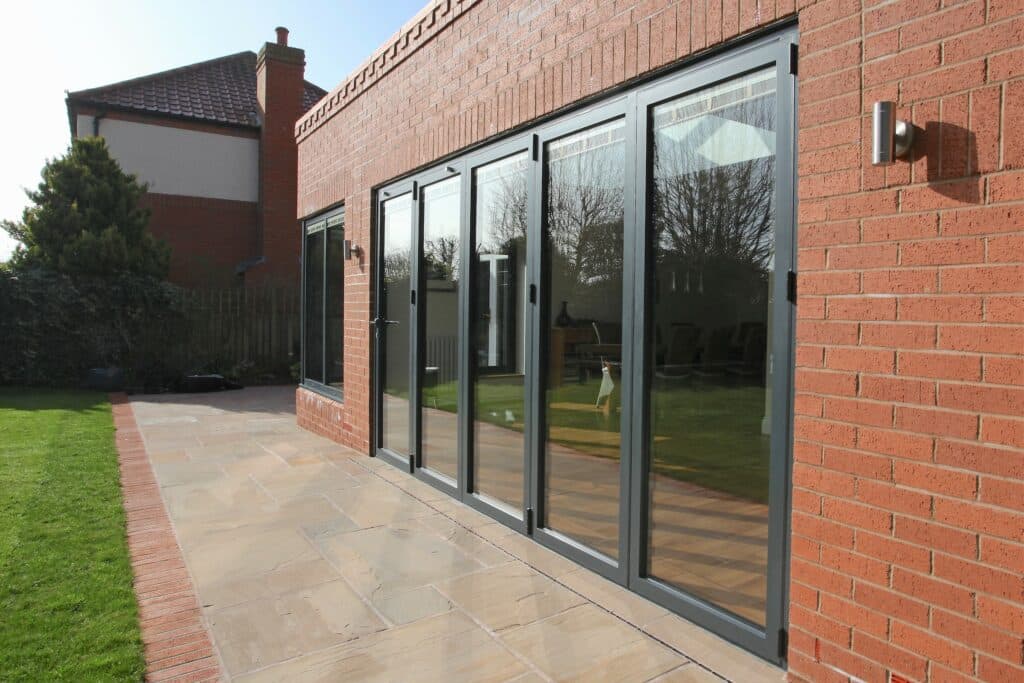 Alutech bifold doors model BF73 closed grey bifold doors in brick opening