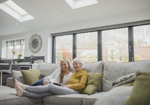 Exlabesa Xlafold bifold doors in grey with couple on a sofa in front