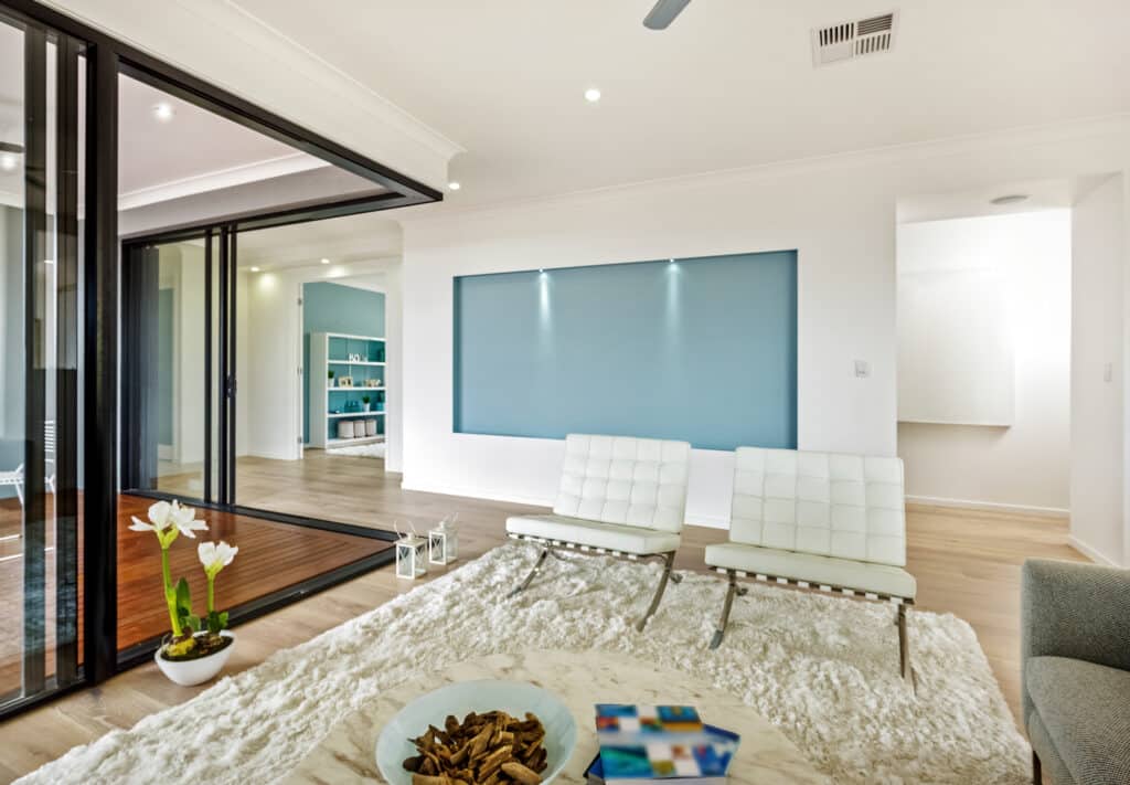 Open corner sliding doors in a modern living room leading out to decking.