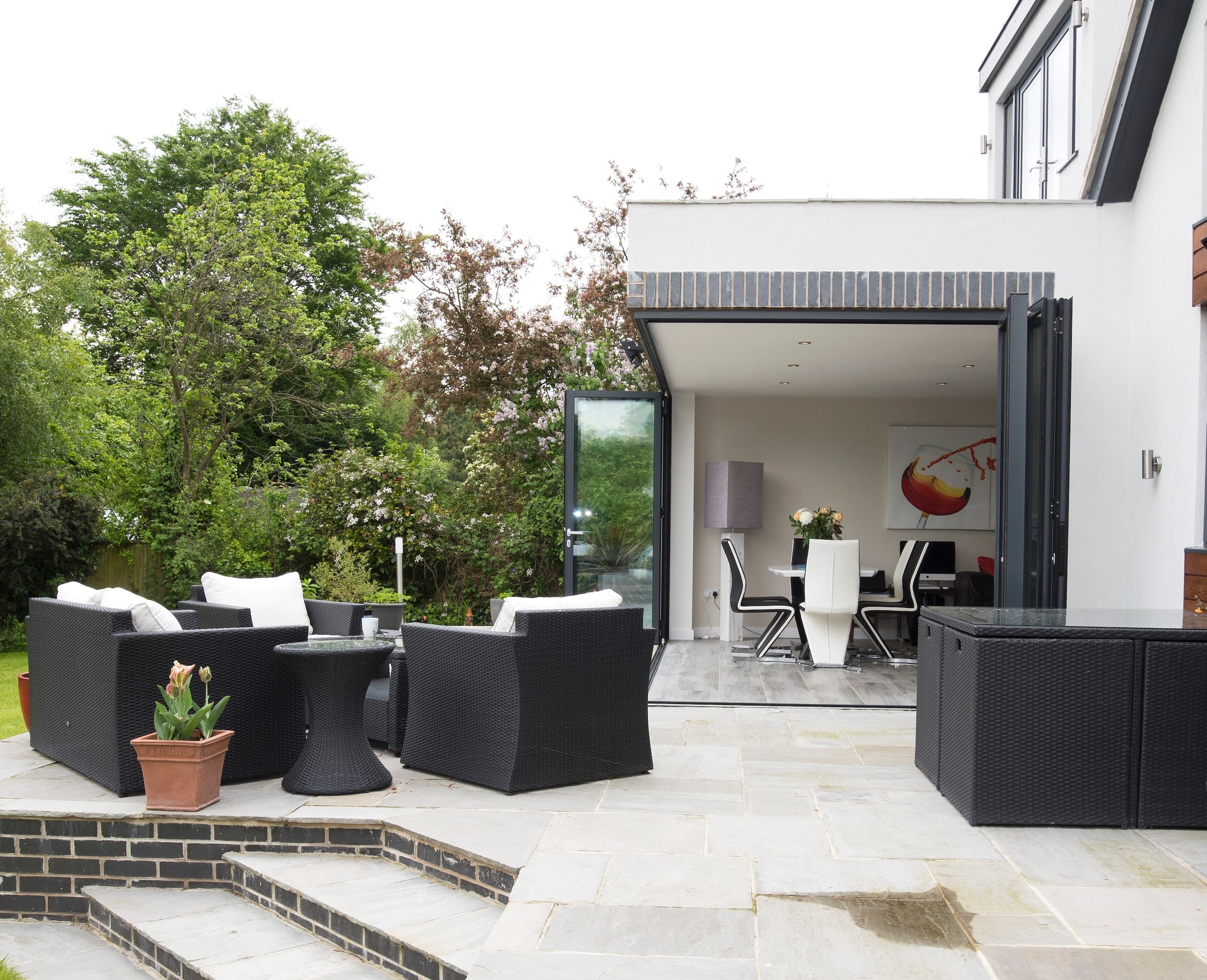 Alumil SF85 bifolds open corner in white rendered house