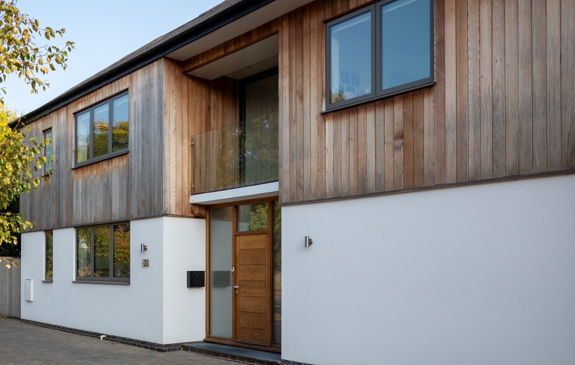 alumil windows in a white render and cedar clad detached house