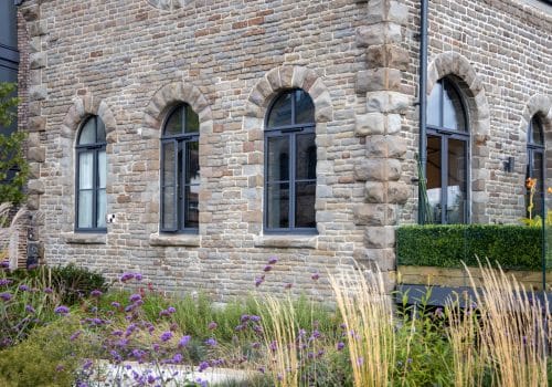 Alumil S85 curved grey windows in a converted chapel