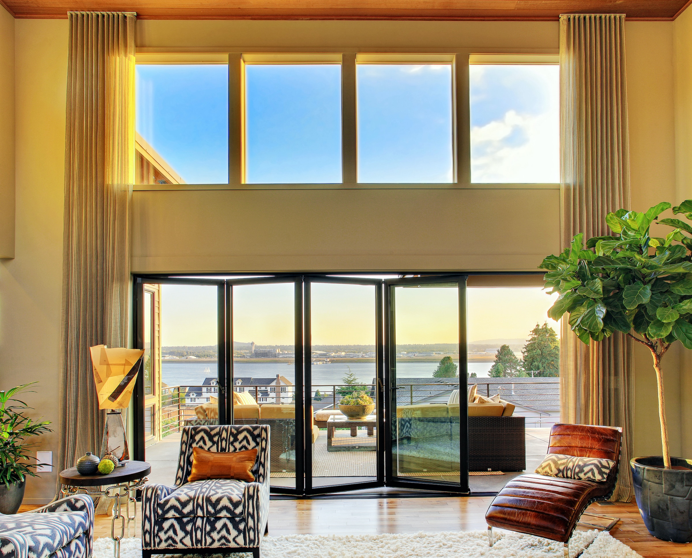 alumil MF65 black bifold doors in a lounge with riverside views