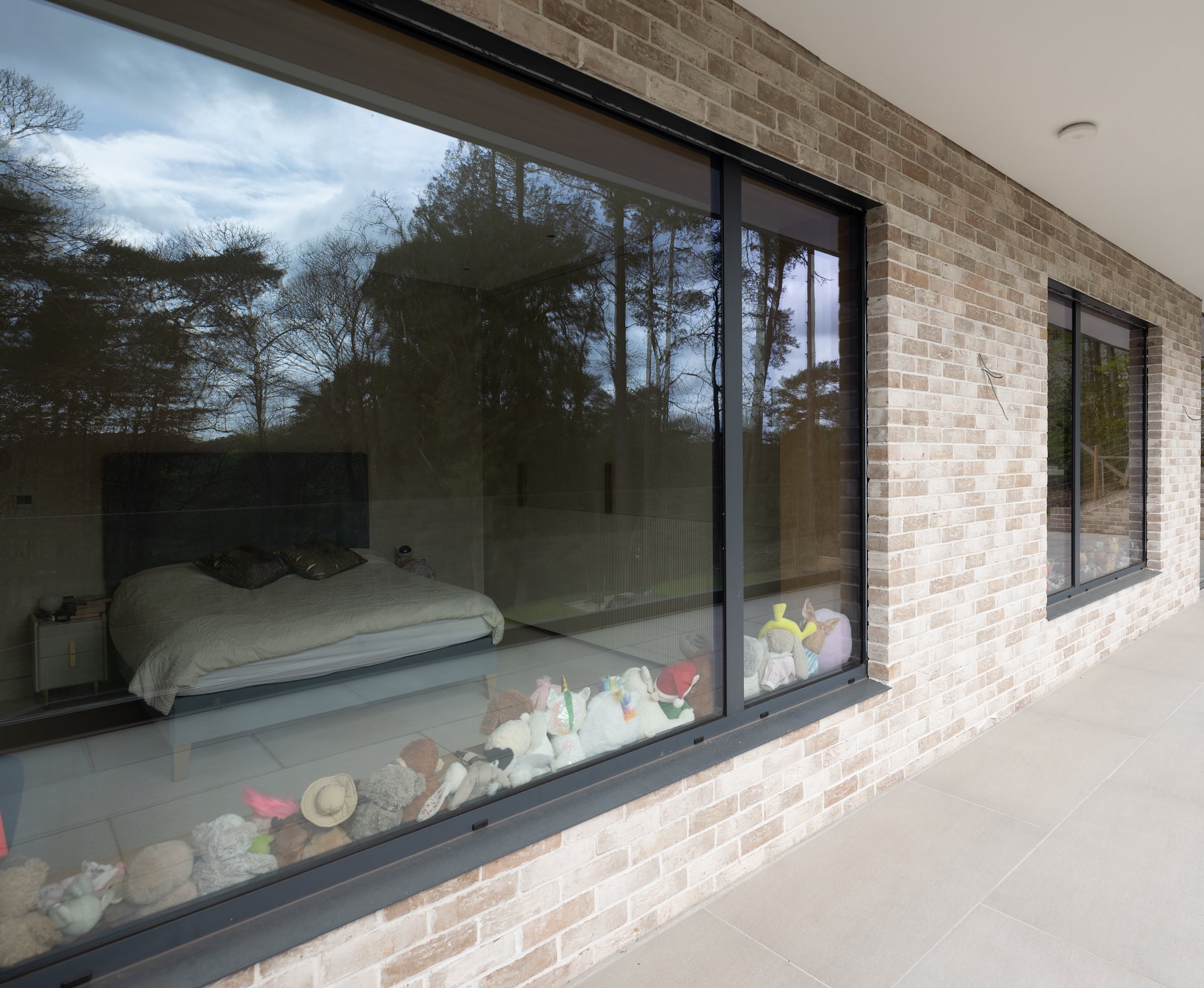bronze tilt and turn window in a stone clad house